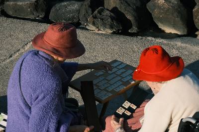 Two people in hats looking at a board