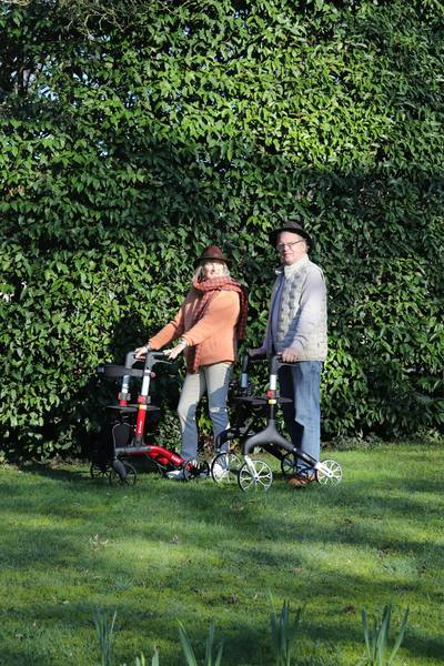 Elderly couple with walkers in a garden