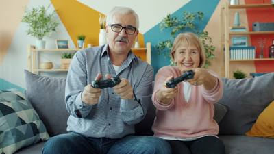 old people husband and wife enjoying videogame playing in apartment sitting