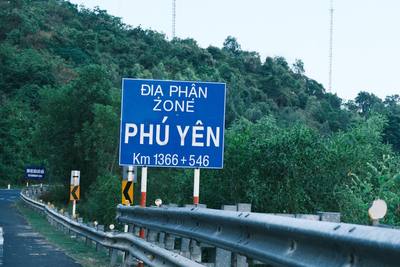 Blue sign indicating phu yen zone on a roadside.