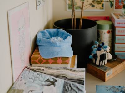 A light blue baseball cap rests on stacked books.